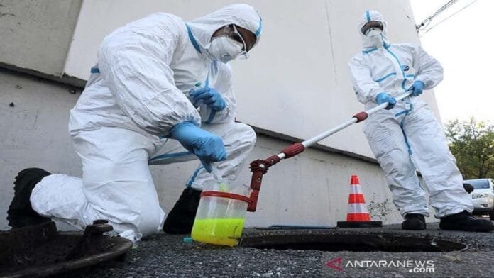 Seorang petugas pemadam kebakaran dari Marins-Pompiers of Marseille mengenakan pakaian pelindung lengkap mengambil sampel air limbah di sekitar rumah jompo untuk mendeteksi jejak konsentrasi COVID-19 yang memasuki gelombang kedua di Marseille, Prancis (28/10/2020). | ANTARA