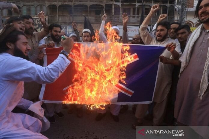 Warga membakar spanduk dengan bendera Prancis yang dicoret dalam aksi protes mengecam penerbitan kartun Nabi Muhammad di Prancis dan komentar Presiden Emmanuel Macron, di Peshawar, Pakistan,Senin,(26/10/2020). ANTARA