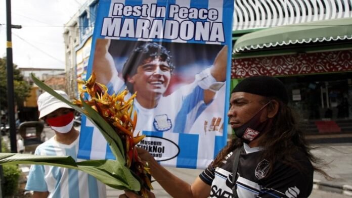Suporter sepakbola Pasoepati mengusung poster ucapan duka cita untuk mengenang legenda sepakbola dunia Diego Maradona yang meninggal dunia saat aksi, di Solo, Jawa Tengah, Kamis (26/11/2020). ANTARA FOTO | MAULANA SURYA