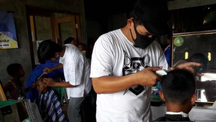 Para pengungsi Gunung Merapi di Desa Deyangan, Kecamatan Mertoyudan, Kabupaten Magelang, mendapat layanan potong rambut gratis. ANTARA | HERU SUYITNO