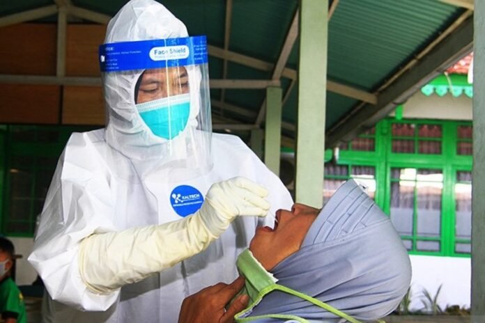 Petugas medis melakukan prosedur pemeriksaan untuk mendeteksi penularan COVID-19 pada seorang penumpang pesawat di Kantor Dinas Kesehatan Kota Pontianak, Kalimantan Barat, Jumat (7/8/2020). ANTARA FOTO | JESSICA HELENA WUYSANG