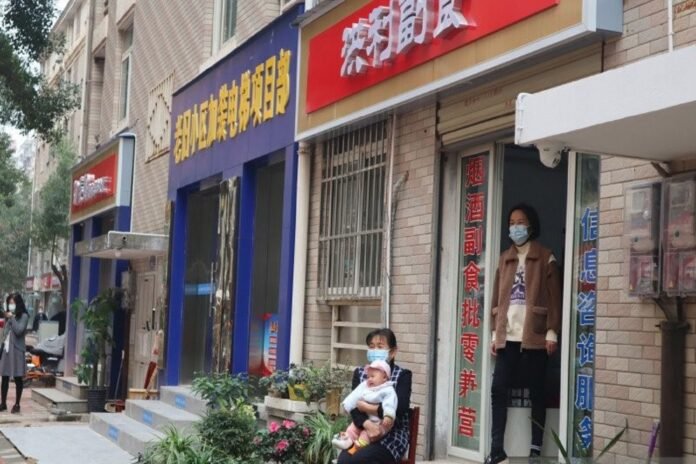 Warga kompleks permukiman Tonghu, Kota Wuhan, Provinsi Hubei, China, bersantai di depan tempat usahanya, Jumat (20/11. ANTARA FOTO | M IRFAN ILMIE