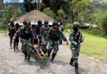 Disela Membangun Gudang Logistik BNPB, Prajurit Yonif 751/VJS Bantu Tandu Warga Sinak Berobat