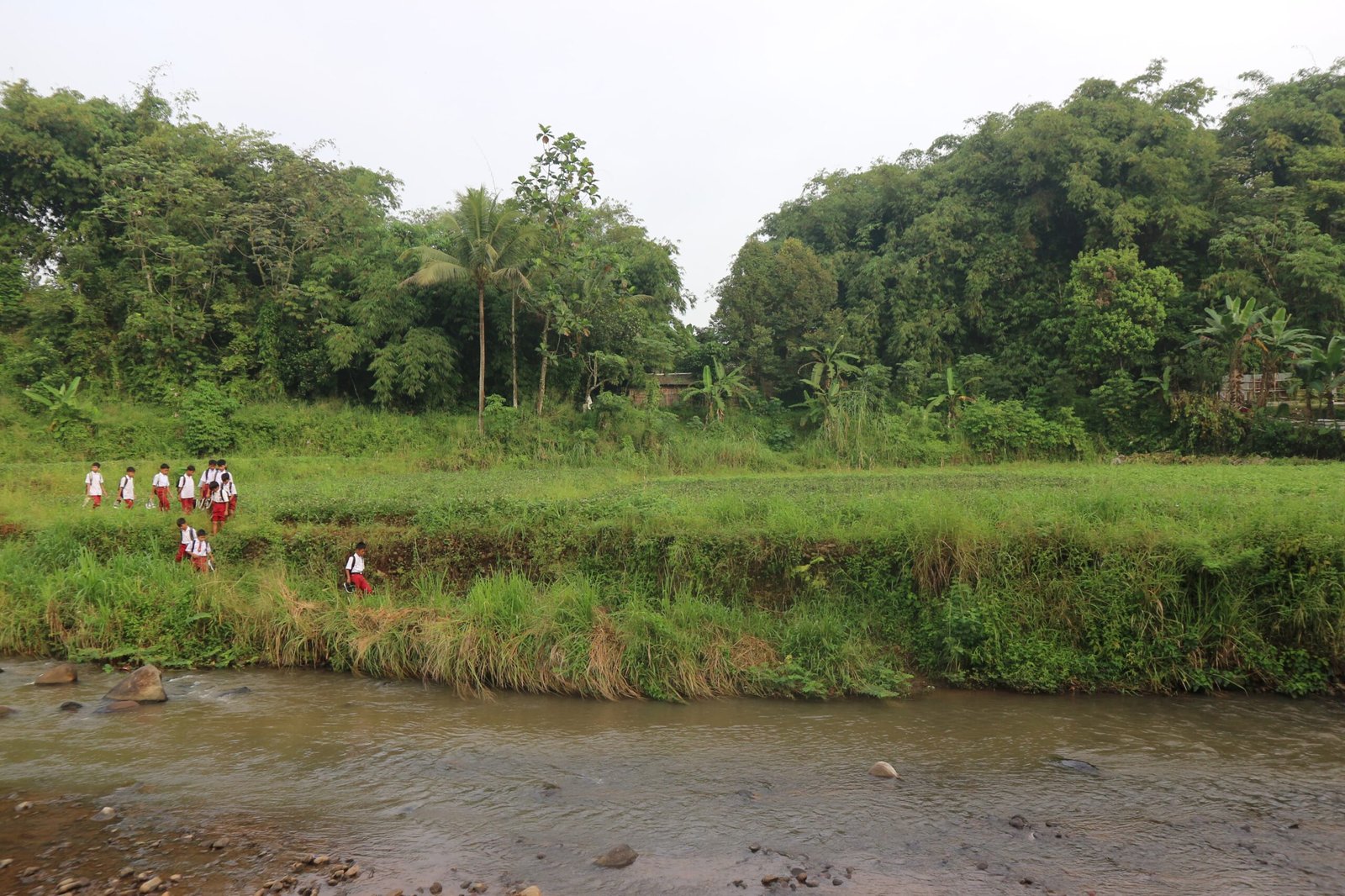 Tak ada yang bisa menghalangi tekad mereka—pelajar Bogor ini berjuang melewati sungai demi masa depan yang lebih cerah. Foto: Harnas.id/ Rangga Firmansyah