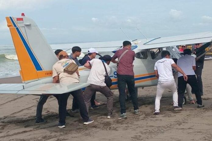 Petugas TNI, Polri, dan Basarnas bersama warga setempat sedang melakukan evakuasi pesawat yang mendarat darurat di Pantai Pangandaran. Foto: Istimewa