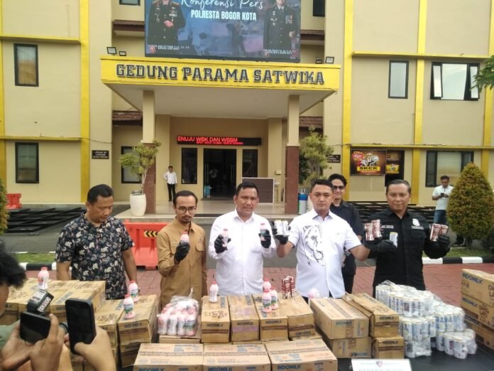 Petugas Satreskrim Polresta Bogor Kota menunjukkan barang bukti ratusan kardus susu kadaluarsa yang dimanipulasi tanggalnya dalam penggerebekan di Bogor dan Depok, Senin (16/6/2025). Foto: Hadi/ harnas.id