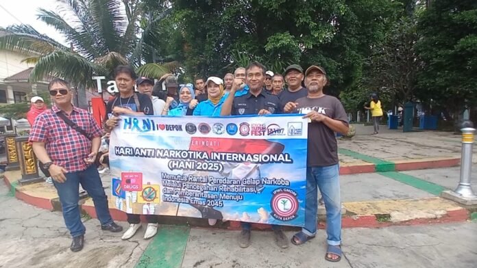 HANI Relawan GMDM Depok membagikan selebaran dan stiker edukasi narkoba kepada pengguna jalan dalam aksi HANI 2025 di kawasan Sukmajaya, Sabtu (29/6/2025). Foto: Harnas.id/ Agung