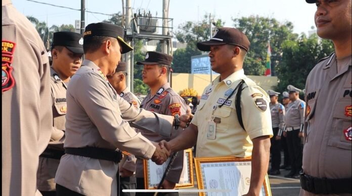 Kapolres Metro Depok, Kombes Pol Abdul Waras, memberikan penghargaan kepada Tri Agus Wiyono dan Burhanudin atas aksi heroik mereka menggagalkan pencurian di Bojongsari, Depok. Foto: Harnas.id/ Agung