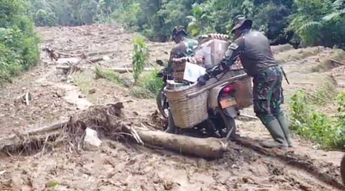 Prajurit TNI AD Koramil 11/Palembayan menembus medan berlumpur untuk menyalurkan bantuan kepada warga terdampak longsor di Silareh Aia, Agam. Foto: Dok. TNI AD.