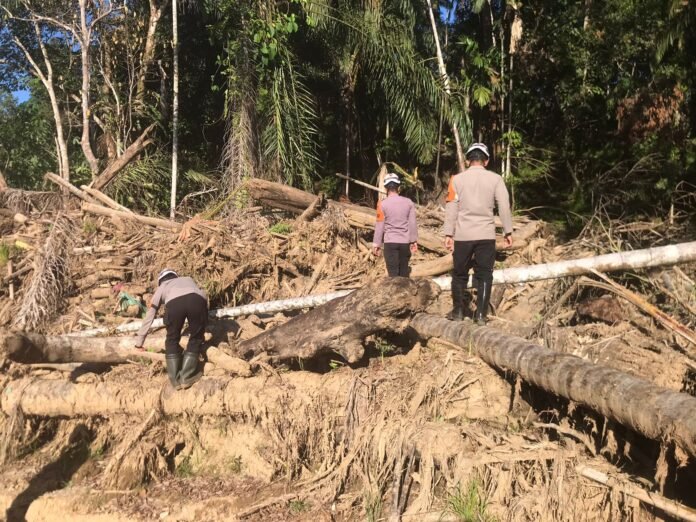 Personel Brimob membersihkan material sisa banjir di bantaran sungai Kabupaten Agam, Sumatera Barat (dok. Polri).