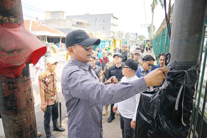 Wakil Wali Kota Bogor Jenal Mutaqin meninjau dan menertibkan token listrik di tiang jalan kawasan MA Salmun–Mayor Oking. Foto: Pemkot Bogor.