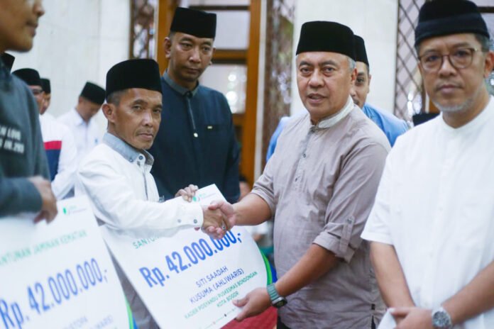 Sekda Kota Bogor Denny Mulyadi menyerahkan bantuan secara simbolis pada peringatan Nuzulul Qur’an di Masjid Baitur Ridwan, Bogor Barat. Foto: Pemkot Bogor