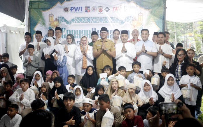 Pengurus PWI Kota Bogor bersama pejabat daerah dan anak yatim berfoto bersama dalam kegiatan santunan Ramadan di Mako PWI Kota Bogor. Foto: PWI Bogor