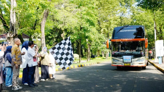 Rektor ITS Prof Dr (HC) Ir Bambang Pramujati ST MScEng PhD (pegang bendera) saat bersiap melepas keberangkatan Mudik Gratis bersama ITS. Foto: Humas ITS