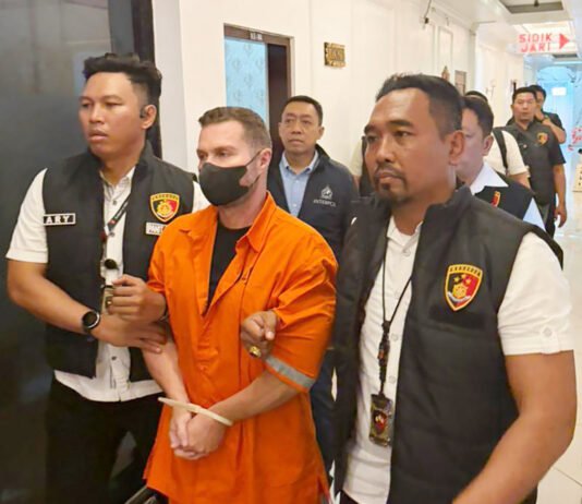 Red Notice Interpol Berujung di Bali, Steven Lyons Diciduk Tanpa Perlawanan Buron Interpol asal Inggris digiring petugas usai diamankan di Bali. Foto: Polri