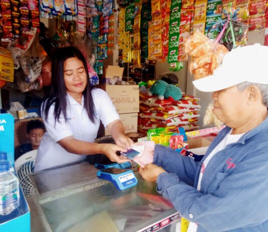 Dari Warung Sembako ke Ribuan Transaksi: Perempuan Palembang Ini “Naik Kelas” Lewat BRILink Agen BRILink perempuan di Palembang melayani transaksi keuangan warga di kios usahanya. Foto: Humas BRI