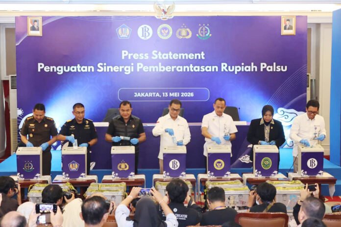 Petugas menunjukkan uang rupiah palsu yang dimusnahkan dalam kegiatan bersama Polri dan Bank Indonesia di Jakarta. Foto: Polri