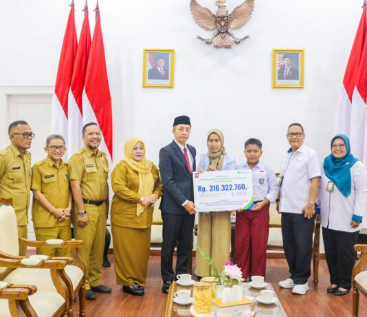 Dedie Rachim Serahkan Santunan untuk Keluarga Staf PUPR Bogor yang Gugur Saat Bekerja Wali Kota Bogor bersama BPJS Ketenagakerjaan menyerahkan santunan kepada ahli waris staf PUPR Kota Bogor yang meninggal akibat kecelakaan kerja. (Dok. Pemkot Bogor)
