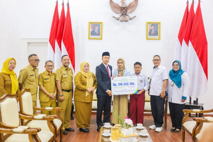 Wali Kota Bogor bersama BPJS Ketenagakerjaan menyerahkan santunan kepada ahli waris staf PUPR Kota Bogor yang meninggal akibat kecelakaan kerja. (Dok. Pemkot Bogor)