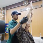 Salah satu tenaga pengajar menjalani pemeriksaan fisik dalam kegiatan fisioterapi gratis di SMA Sunda Kelapa. Foto: Harnas.id