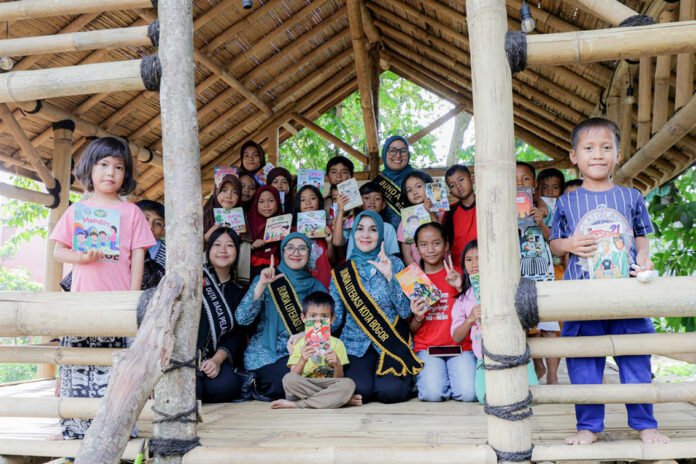 Yantie Rachim membaca buku bersama anak-anak saat peresmian Jemari PKK dan TBM di Bubulak, Kota Bogor. Foto: Pemkot Bogor