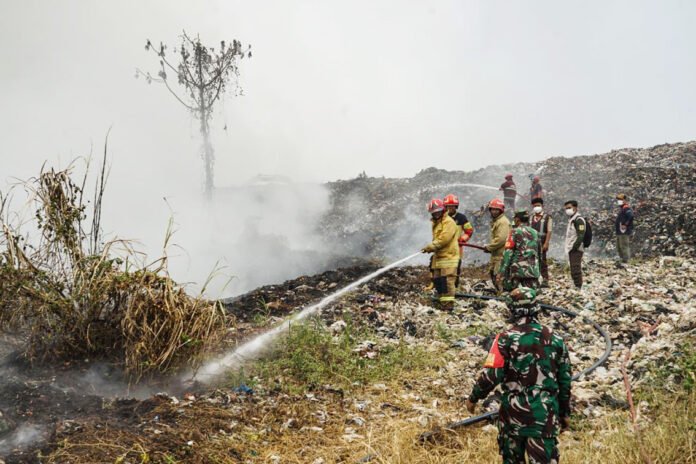Petugas gabungan menangani kebakaran di kawasan TPAS Galuga, Bogor. Foto: Harnas.id