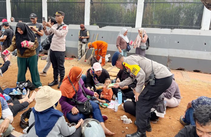 Brimob dan Polwan Polda Metro Jaya membagikan roti kepada peserta Hari Tani Nasional di depan Gedung DPR/MPR RI, Jakarta. Brimob