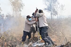 Personel kepolisian berupaya mengendalikan kebakaran hutan dan lahan guna mencegah api meluas ke area sekitarnya. Foto: HArnas.id