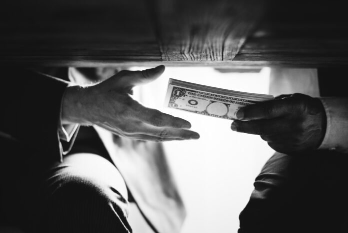 Hands passing money under table corruption bribery Ilustrasi tindak pidana korupsi yang menjadi perhatian dalam penegakan hukum dan upaya pemberantasan korupsi di Indonesia. Foto: Istimewa